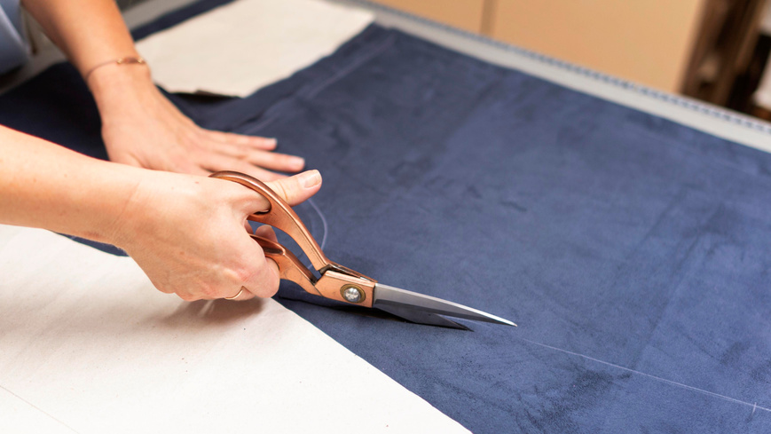 hands cutting material with scissors close up